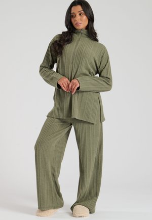 Ensemble assorti vert olive comprenant un haut zippé à côtes et un pantalon large au toucher doux. Inclut des chaussons beige.