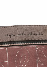 Tessuto marrone texture con un motivo cucito e una cerniera superiore. La frase "stile con attitudine" è impressa su una rifinitura marrone chiaro.