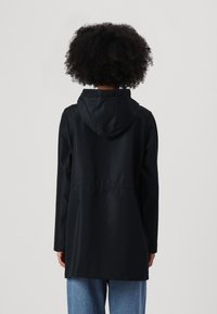 Černá voděodolná bunda s kapucí, dlouhými rukávy a zúženým pasem. Hladký povrch a design ke kolenům.