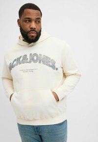 Kremowa bluza z kapturem z przednią kieszenią kangurkową, z nadrukowanym logo „JACK & JONES” w kolorze szarym. Miękka tkanina, ściągacze przy rękawach i w pasie.