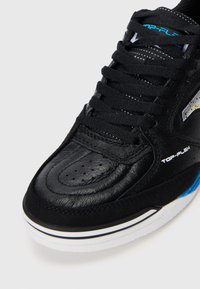Sort lædersneaker med tekstureret overflade, tykke sorte snørebånd og hvid ydersål med blå detaljer. Perforeret tåområde for åndbarhed.