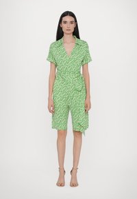 Robe enveloppante verte avec des manches courtes, ornée d'un motif de feuilles blanches, en tissu texturé, et une ceinture à nouer à la taille.