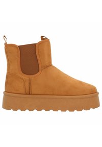 Brun mocka ankelboot med elastiska sidopaneler, rund tå och en texturerad gummisula. Har en låg plattformdesign för stabilitet.
