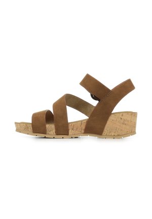 Sandales compensées en daim marron avec une semelle en liège. Présente trois larges brides à l'avant et une seule sangle de cheville pour le soutien.
