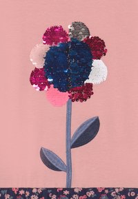 Tela rosa con un diseño floral hecho de lentejuelas en varios colores, con un tallo azul oscuro y un borde inferior floral en color oscuro.