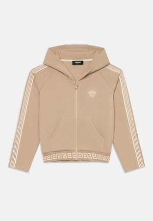 Béžová mikina na zips s kapucňou, s malým vyšitým logom, dvoma prednými vreckami a bielymi pruhmi na rukávoch a v páse.