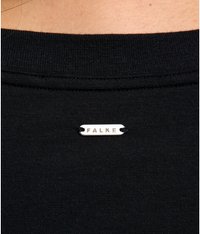 Schwarzer Stoff mit gerippter Textur; enthält ein kleines silbernes Etikett mit dem Text "FALKE", das hinten in der Nähe des Kragens angebracht ist.
