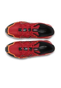 Chaussures de sport rouges avec accents noirs, tige en mesh et détails oranges. Elles possèdent un bout arrondi et une semelle intérieure rembourrée avec des lacets.