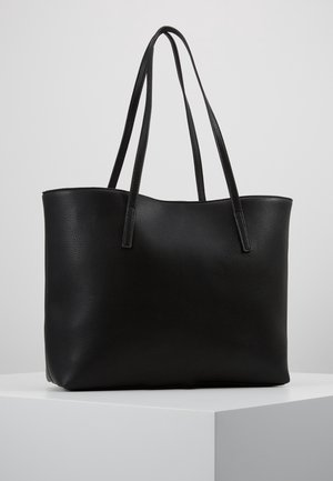 Zwart leren tote tas met dubbele lange handvatten, getoond op een wit voetstuk tegen een effen lichtgrijze achtergrond.