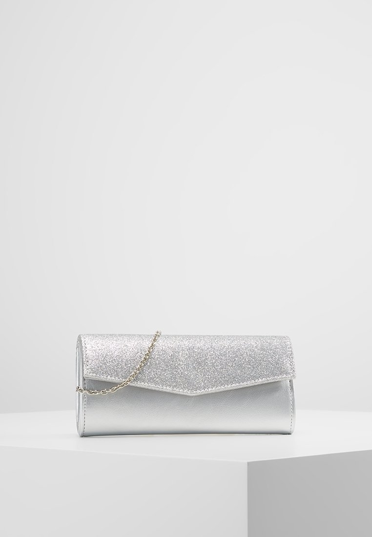 Bolso de mano plateado con una solapa frontal brillante, cuerpo metálico liso y una correa de cadena. Presenta una forma rectangular y un diseño angular.