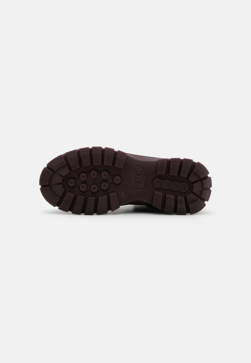 Zool van een schoen, vervaardigd uit duurzaam donkerbruin rubbermateriaal. Het profielontwerp omvat brede groeven en cirkelvormige patronen voor grip.