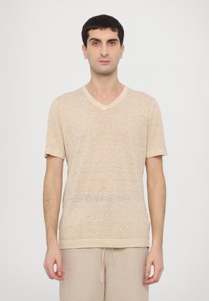 T-shirt beige à col en V, fabriqué en tissu léger et texturé, avec des manches courtes et une coupe décontractée. Assorti à un short beige.