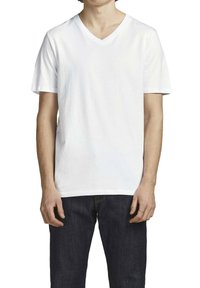 Hvid v-hals t-shirt lavet af bomuld, korte ærmer, afslappet pasform, ensartet tekstur, sat sammen med mørkeblå denimjeans.