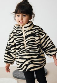 Zebra-gestreifter Fleece-Pullover in Creme und Schwarz. Mit hohem Kragen und halbem Reißverschluss vorne. Lockere Passform mit weiten Ärmeln und weichem Material.