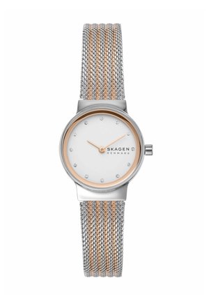 Zilveren en roségouden mesh band horloge met witte wijzerplaat, roségouden wijzers, kristallen uurmarkeringen en het logo "Skagen Denmark" op de wijzerplaat.