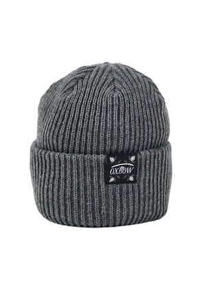 Bonnet en tricot gris avec une texture côtelée et un revers, comportant un patch logo Oxbow noir à l'avant.