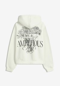 Fehér, rövidített kapucnis pulóver, amely grafikai nyomattal díszített, újságban megjelenő virágokkal és a "HÍREK" és "AMBÍCIÓ" feliratokkal. Pamut anyagból készült, laza szabású.