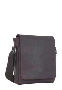 Borsa a tracolla in pelle marrone con pattina anteriore, dettagli in metallo argento e una tracolla in tessuto, caratterizzata da una texture sottile e un branding minimale.