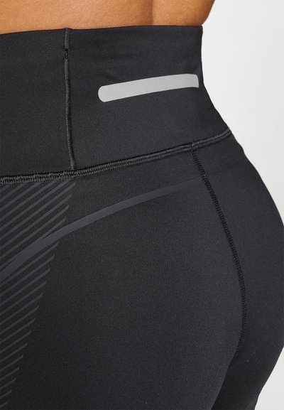 Fekete, magas derekú leggings, sima, rugalmas anyagból, fényvisszaverő részlettel és oldalt átlós csíkmintával.