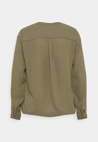 Oliwkowa bluzka z długimi rękawami, miękka tkanina, okrągły dekolt i mankiety zapinane na guziki. Posiada minimalne szwy i gładką fakturę.