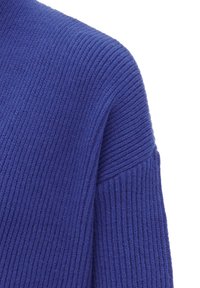 Rippstrickpullover in einem tiefen Blauton, mit hohem Kragen und einer Textur, die weich und warm erscheint.
