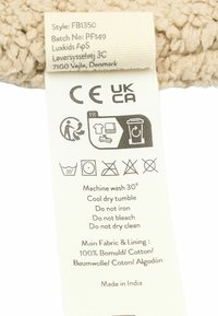 Etiqueta para producto textil con instrucciones de cuidado. Color beige, material de algodón. Contiene símbolos para instrucciones de lavado y secado.