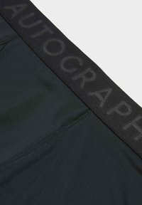 Shorts neri elasticizzati in tessuto morbido, con una vita elastica decorata da lettering in rilievo e dettagli di cuciture piatte.