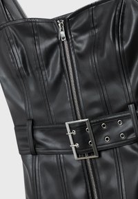 Robe noire en similicuir avec coutures verticales, fermeture éclair argentée sur le devant et large ceinture avec boucle double ardillon argentée.