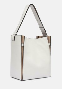 Sac fourre-tout en cuir blanc avec une texture douce, présentant un contour noir contrastant et des panneaux latéraux beige clair. Bandoulière réglable.