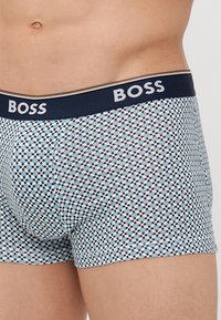 Boxer shorts pour hommes avec un motif à pois bleu et blanc, tissu doux et une taille élastique navy avec le logo 'BOSS'.