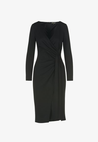 Vestido negro de manga larga con diseño cruzado, que presenta un lazo en la cintura y una sutil abertura en la parte delantera. Fabricado con una tela elástica.