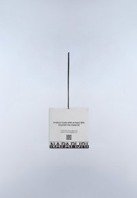 Etiqueta de ropa colgada por un cordón negro indica que el producto está hecho con al menos un 30% de material reciclado e incluye un código QR y la marca Napapijri.