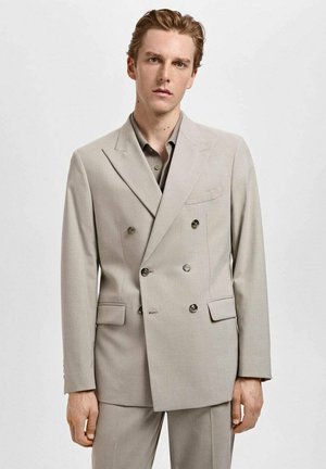 Beige double-breasted suit jacket with notched lapels, two front pockets, and button details, made of a smooth, textured fabric.