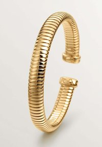 Pulsera en tono dorado con un diseño flexible y acanalado que presenta un acabado suave y un cierre en cada extremo para un cierre seguro.