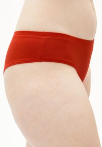 Sous-vêtements hipster rouges en coton doux et élastique. Présentent un design sans coutures avec une large ceinture et une texture lisse.