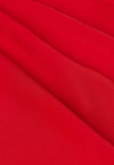 Red fabric, smooth texture, with a deep hue and slight sheen. Material is soft and drapes elegantly, showing subtle folds and curves.