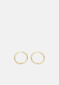 Boucles d'oreilles en or à anneaux avec une surface texturée et irrégulière, en forme de petites boucles, dotées d'un fermoir sécurisé pour les porter.