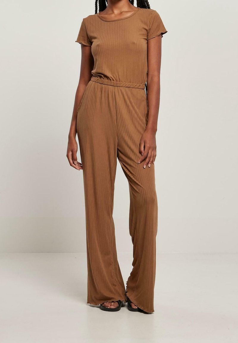 Combinaison marron à côtes avec des manches courtes, taille cintrée, pantalon large et texture subtile. Assortie avec des sandales plates.