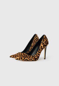 Lauku raksta augstpapēžu kurpes ar norādītu pirkstu dizainu, izgatavotas no teksturēta auduma, ar melnu iekšpusi un stiletto papēdi.