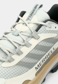 Merrell trekking sko med en overdel af grå mesh, mønstret overlay, beige accenter og struktureret sål. Har et let design og sikker snørre.