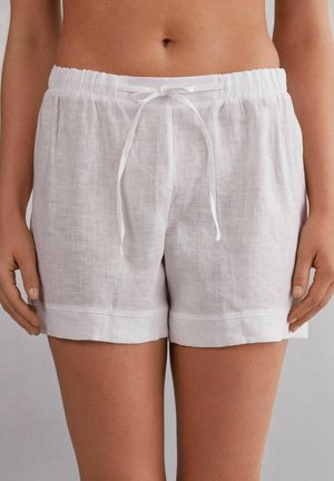 Weiße Leinen-Shorts mit einem lockeren Schnitt, elastischem Bund und vorderer Bindegarnitur, ausgestattet mit umgeschlagenen Säumen und einer leichten Textur.