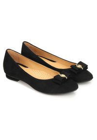 Black suede ballet flats with rounded toes, gold logo accent, and bow detail at the front. Beige padded interior with perforated design.