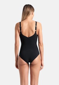Black one-piece swimsuit featuring adjustable straps and a low back design. Made from smooth fabric with a fitted silhouette.