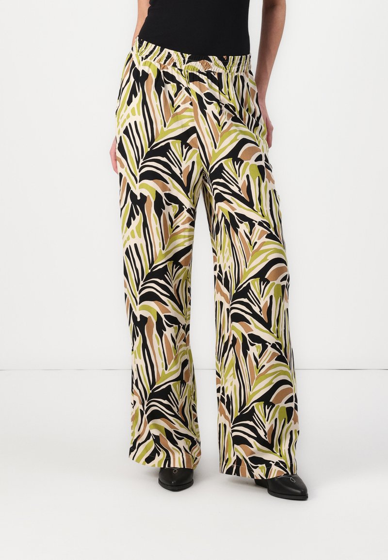 Wide-leg pants featuring a vibrant leaf pattern in green, black, and shades of brown. Elastic waistband. Lightweight fabric with a smooth texture.