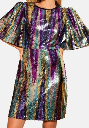 Frau trägt ein knielanges, mehrfarbiges Pailletten-Kleid mit breiten, ellbogenlangen Puffärmeln und vertikalen Streifen in Lila, Gold, Türkis und Schwarz.