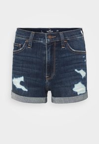 Džínové šortky tmavě modré barvy s opraným okrajem, s lehkými opranými místy a tradičním pětikapsovým designem. Zapínání na knoflík a zip.