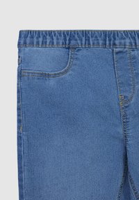 Pantaloni in denim blu con vita elastica, tasca frontale singola e cuciture gialle visibili lungo le cuciture e le tasche. Texture liscia.