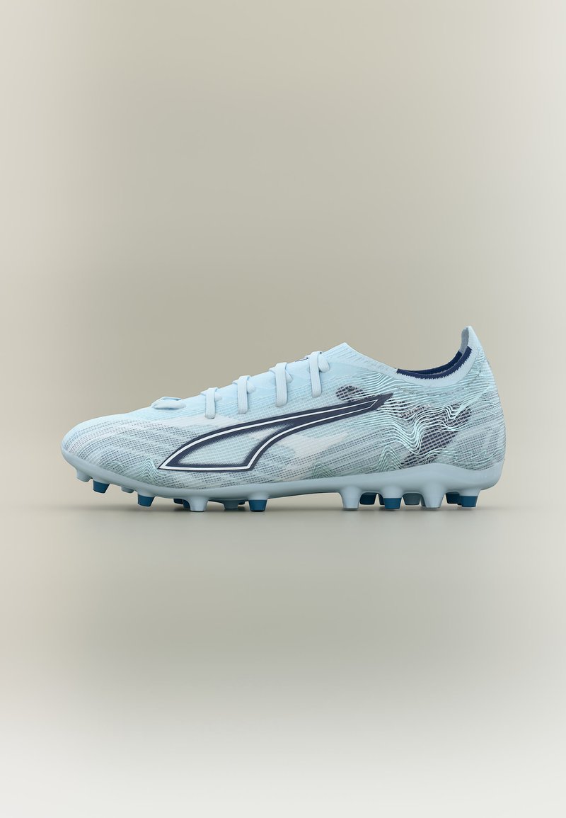 Light blue football boot with dark blue logo and studs, textured upper, and sock-like ankle collar against neutral background.