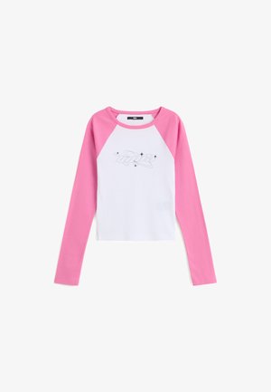 Langärmliges Hemd mit weißem Körper, rosa Raglanärmeln, einem kurzen Schnitt und einem schwarzen grafischen Muster auf der Vorderseite.