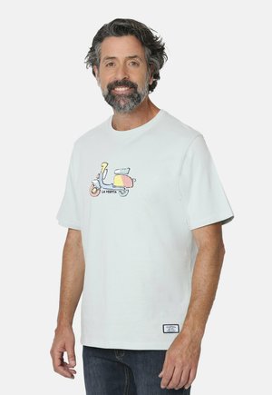 Camiseta de algodón blanca con un ajuste relajado, que presenta un gráfico colorido de un scooter en el frente y una pequeña etiqueta de marca en el dobladillo.